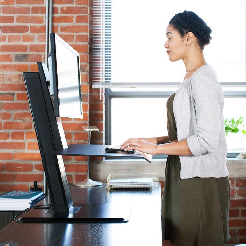 woman using a computer on a standing desk
